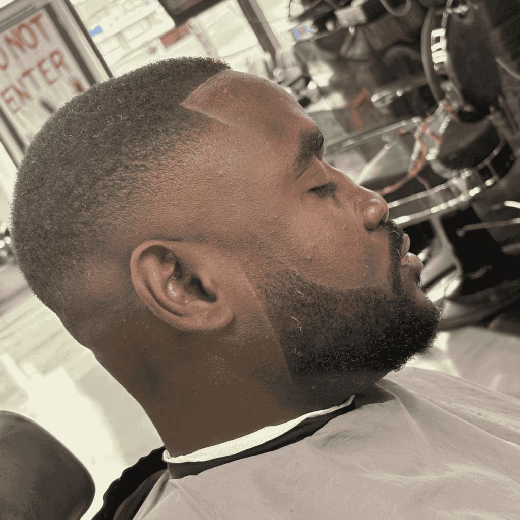 Close-up of a sharp, clean skin fade and groomed beard performed by a master barber.