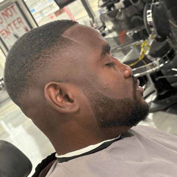 Side view of a precision mid-skin fade and expertly lined-up beard by a Cut Throat barber.