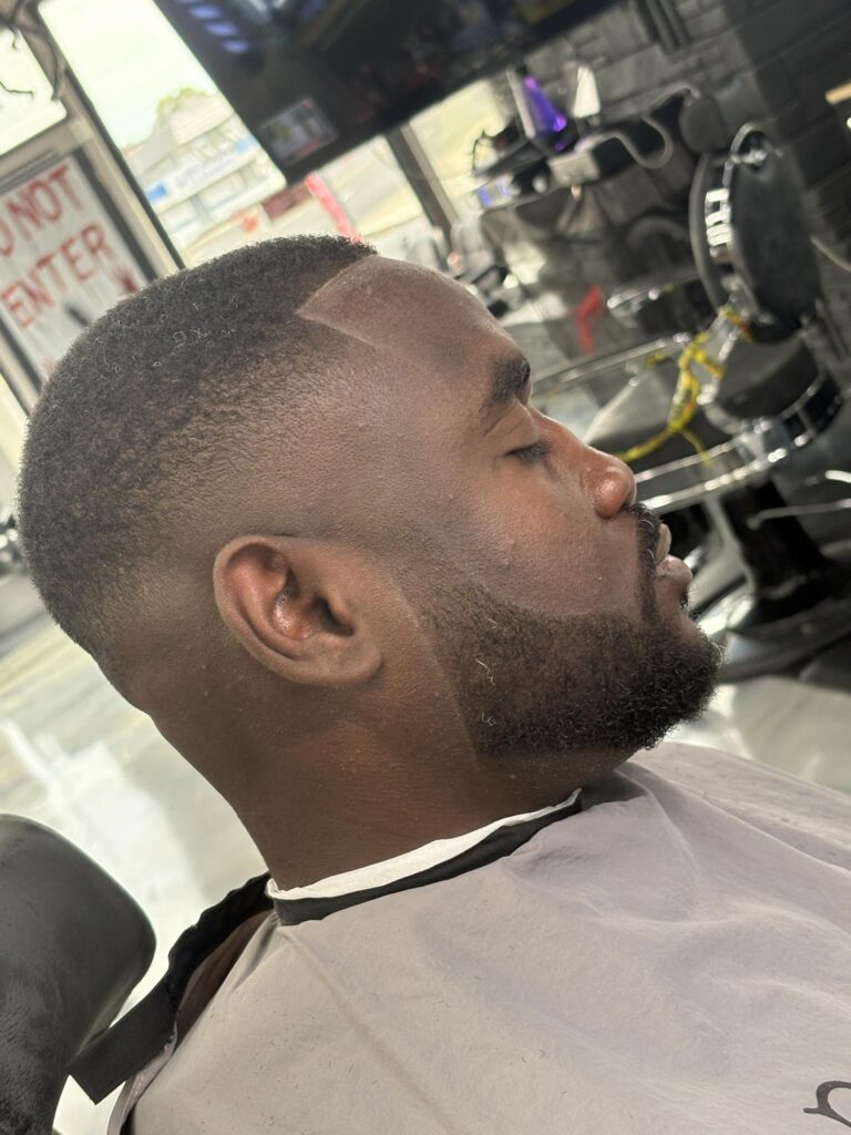 Close-up of a sharp, clean skin fade and groomed beard performed by a master barber.